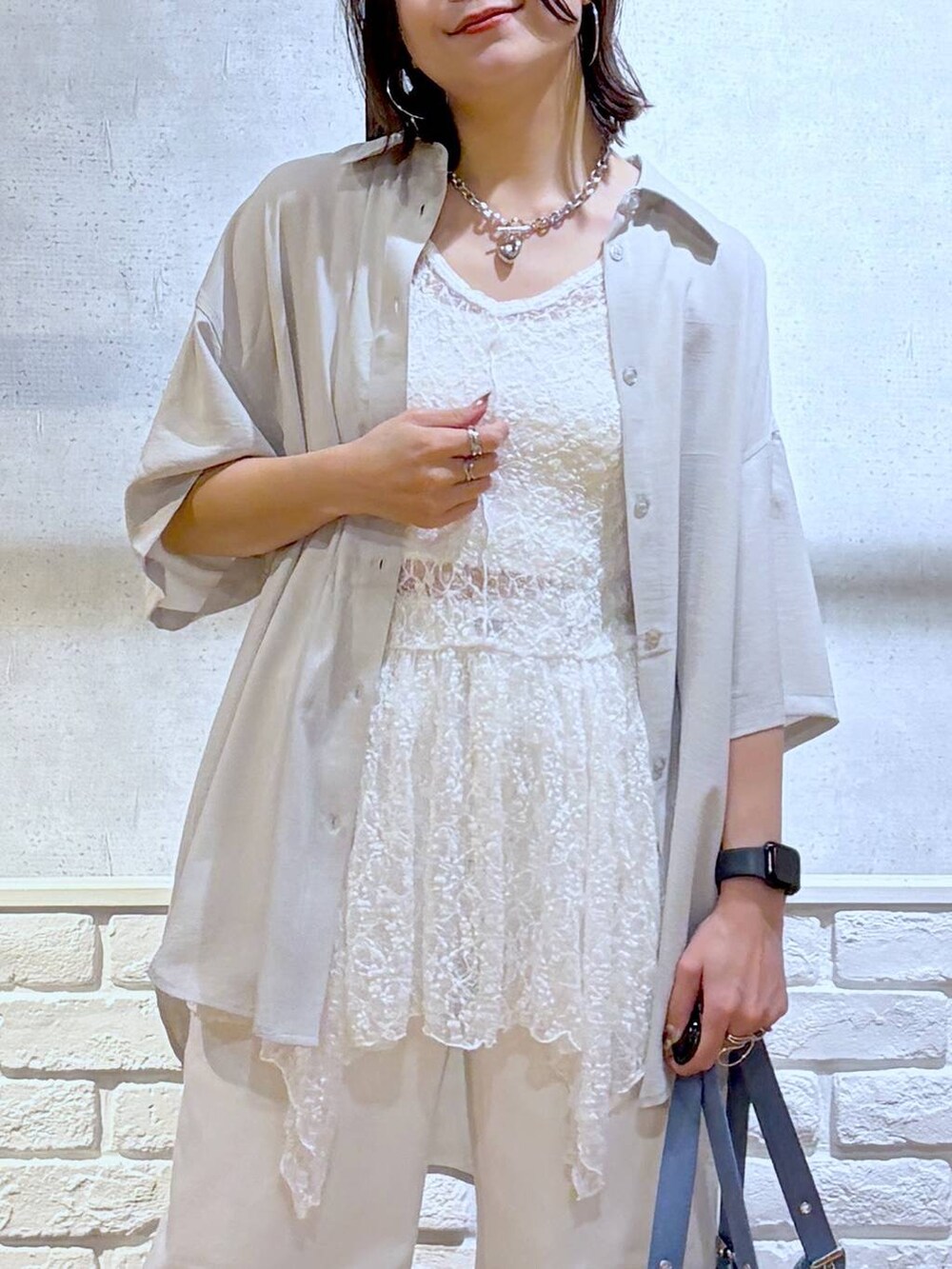 ホワイト系のデニムパンツ、その他のサンダル、ブルー系のハンドバッグを着用したレディースの夏コーディネートの2枚目の写真