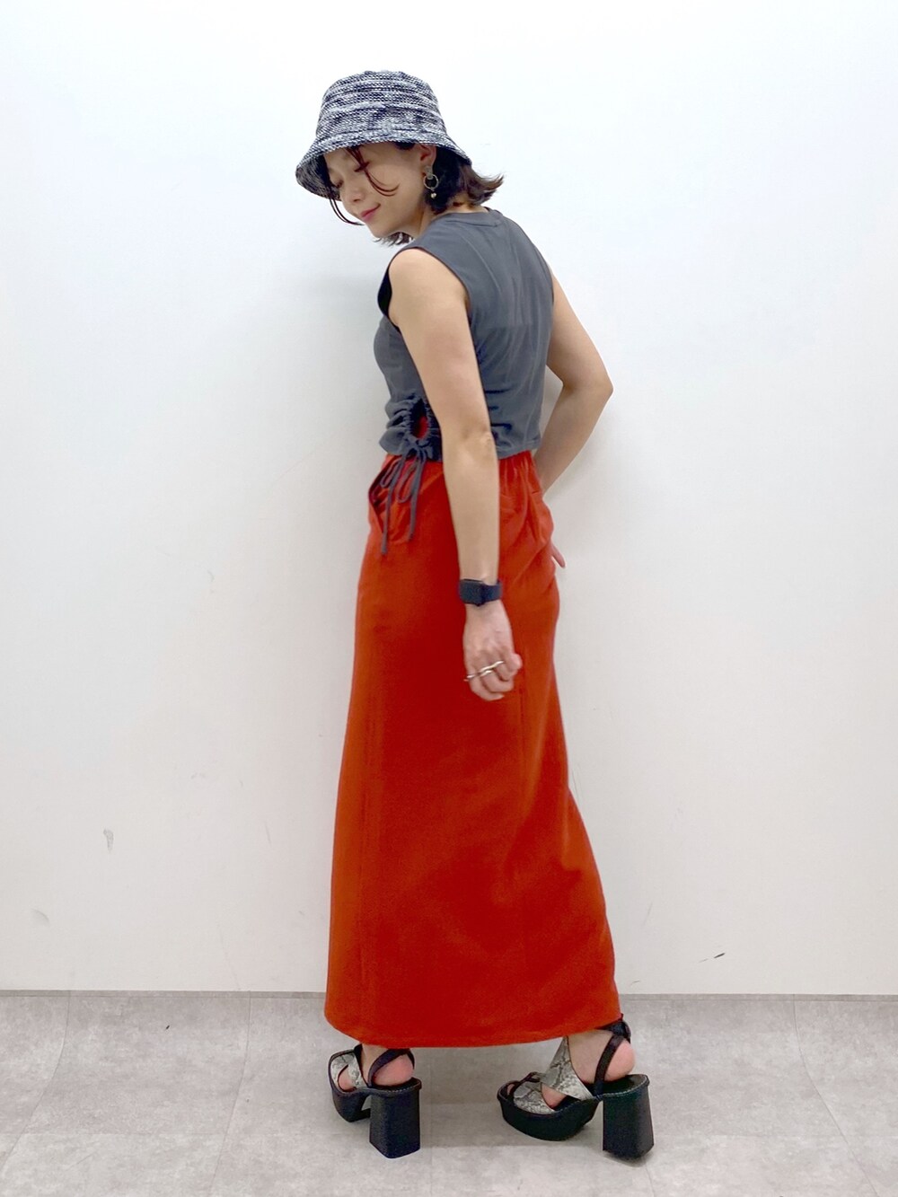 ホワイト系のサンダル、オレンジ系のスカート、グレー系のTシャツ/カットソーを着用したレディースの夏コーディネートの5枚目の写真