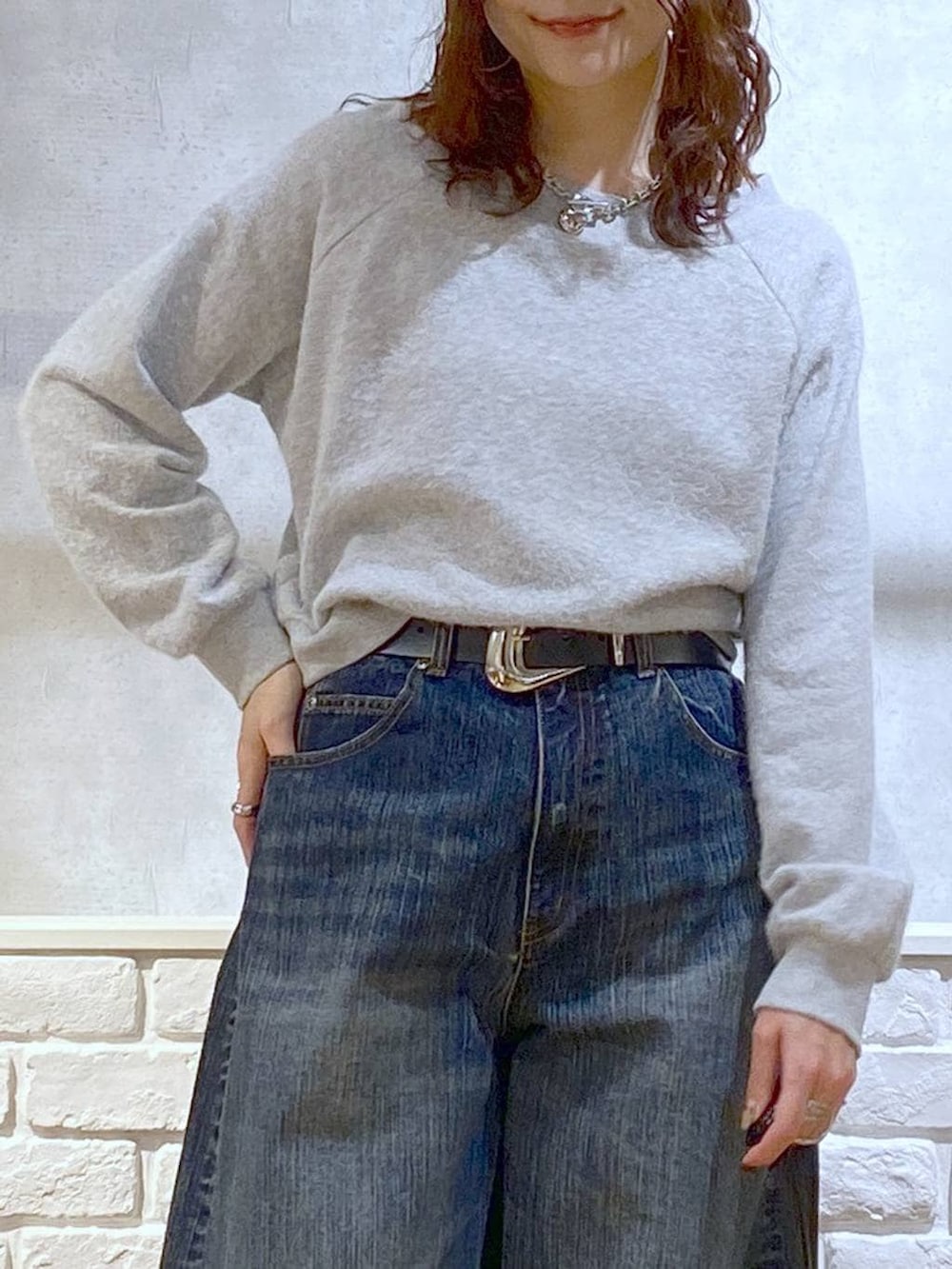 ブラック系のブーツ、ブルー系のデニムパンツ、その他のハンドバッグを着用したレディースの冬コーディネートの2枚目の写真