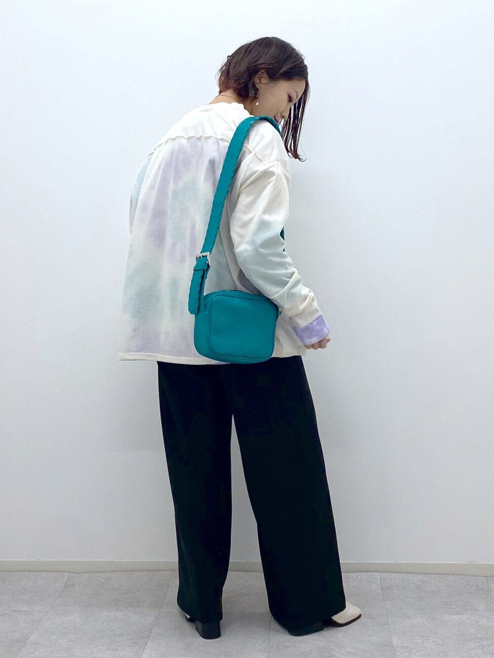 ブラック系のスラックス、ホワイト系のTシャツ/カットソー、ホワイト系のTシャツ/カットソーを着用したレディースの冬コーディネートの3枚目の写真