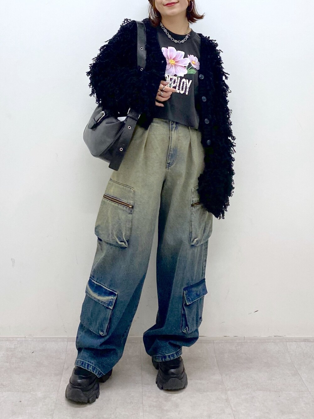 ブルー系のデニムパンツ、ブラック系のTシャツ/カットソー、ブラック系のカーディガン/ボレロを着用したレディースの秋コーディネートの4枚目の写真