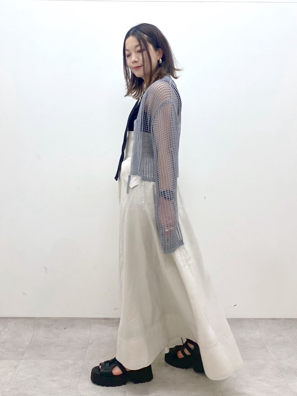 ブラック系のキャミソール、グレー系のカーディガン/ボレロ、ベージュ系のスカートを着用したレディースの春コーディネートの8枚目の写真