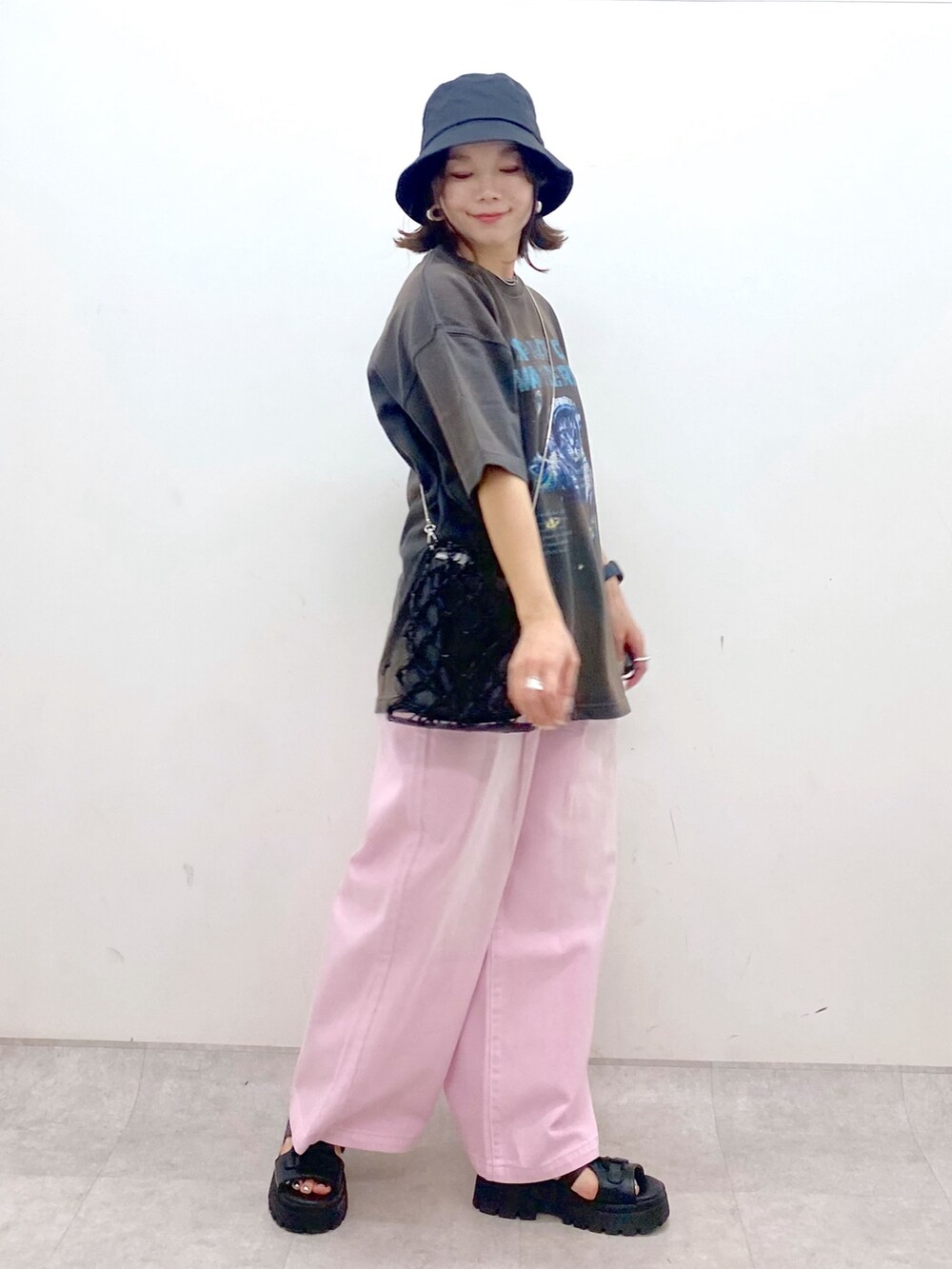 ピンク系のデニムパンツ、ブラック系のサンダル、ブラック系のショルダーバッグを着用したレディースの夏コーディネートの5枚目の写真