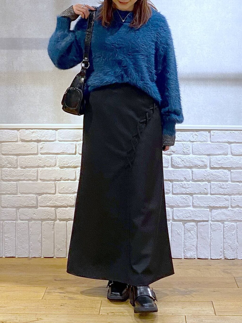 シルバー系のTシャツ/カットソー、ブラック系のブーツ、ブルー系のニット/セーターを着用したレディースの冬コーディネートの3枚目の写真