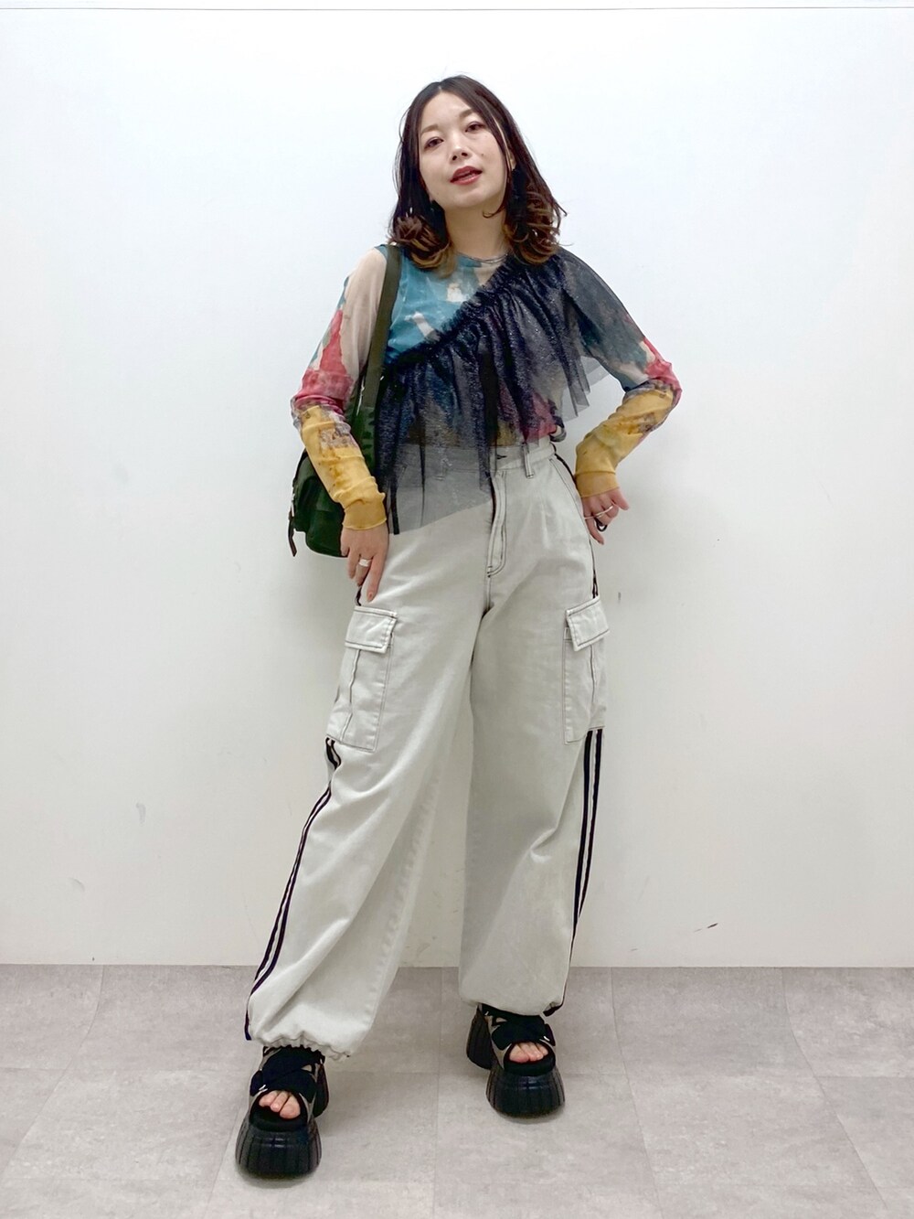 グリーン系のショルダーバッグ、その他のスニーカー、ホワイト系のデニムパンツを着用したレディースの春コーディネートの9枚目の写真