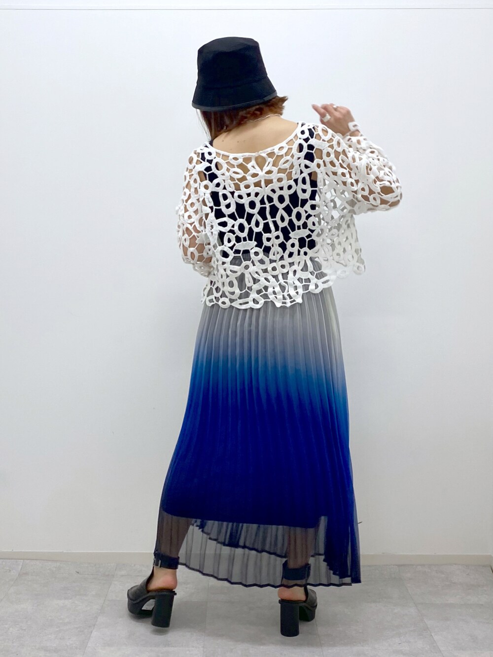 ブルー系のスカート、ブラック系のタンクトップ、ブラック系のサンダルを着用したレディースの春コーディネートの4枚目の写真