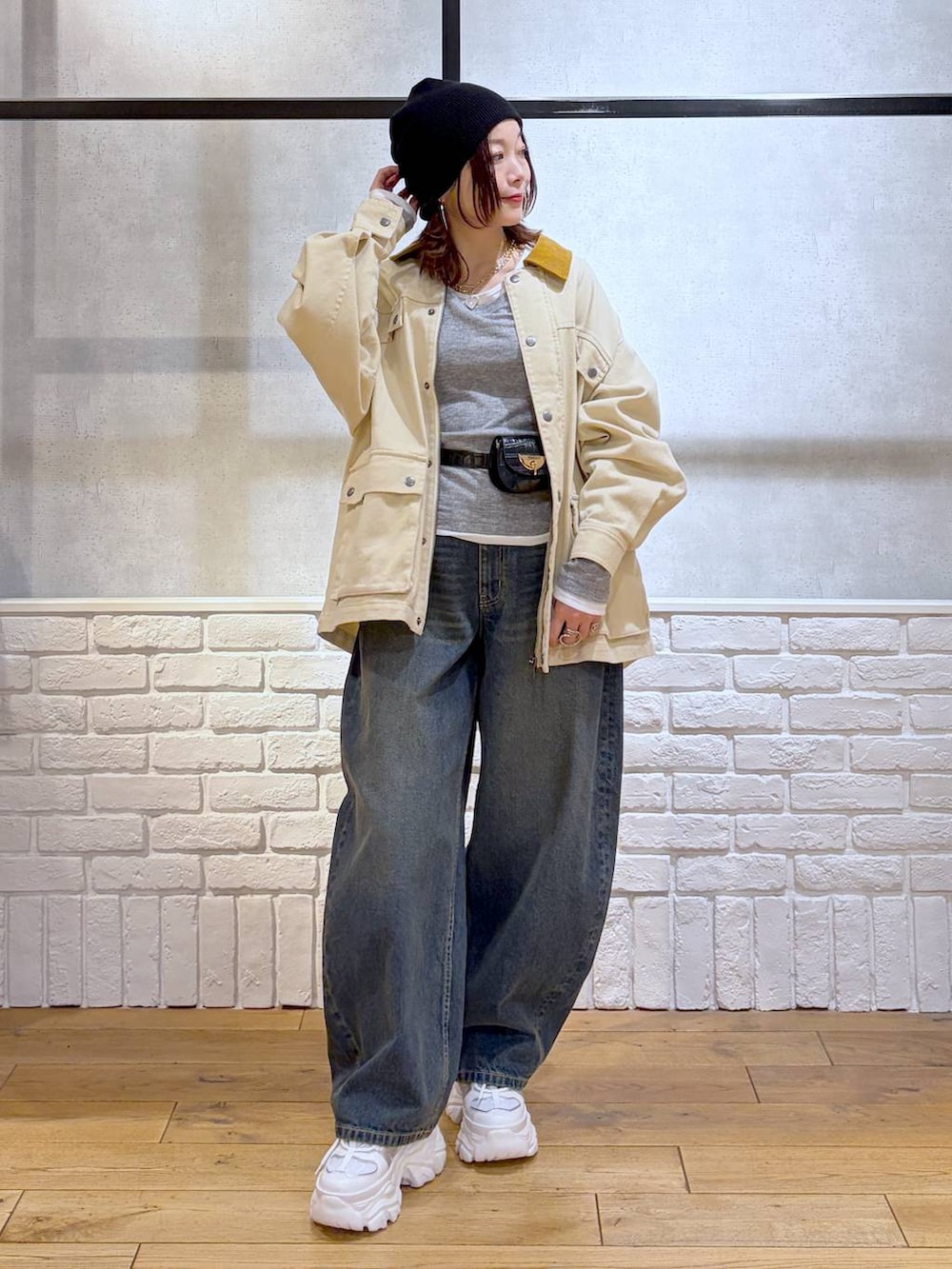 ホワイト系のスニーカー、ブラック系のボディバッグ/ウエストポーチ、ブルー系のデニムパンツを着用したレディースの冬コーディネートの8枚目の写真