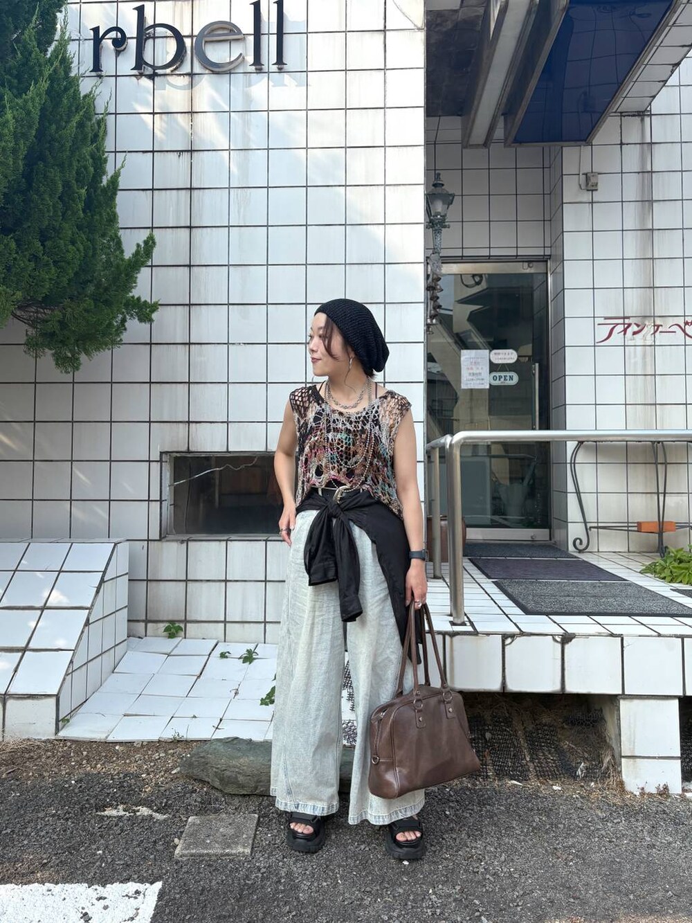 ブルー系のデニムパンツ、その他のベスト、ブラウン系のボストンバッグを着用したレディースの夏コーディネートの2枚目の写真