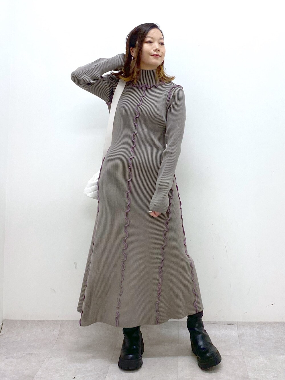 ブラウン系のワンピース、ホワイト系のショルダーバッグ、ブラック系のブーツを着用したレディースの秋コーディネートの9枚目の写真