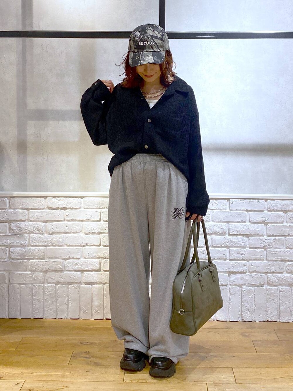 ブラック系のスニーカー、グリーン系のボストンバッグ、グレー系のスウェットパンツを着用したレディースの秋コーディネートの8枚目の写真