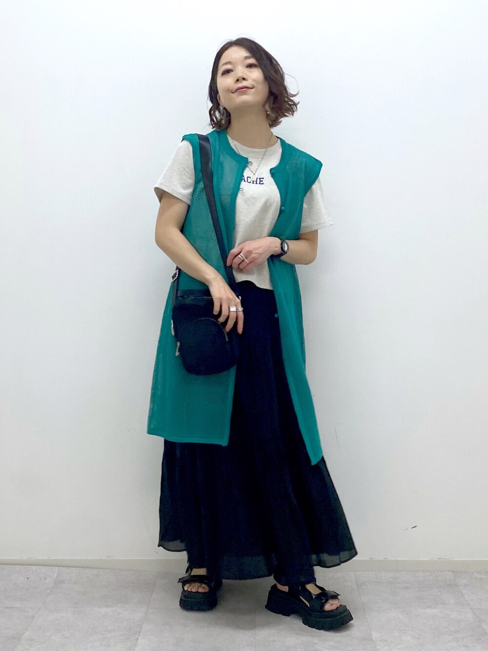 ブラック系のサンダル、ブラック系のショルダーバッグ、ブラック系のスカートを着用したレディースの春コーディネートの5枚目の写真