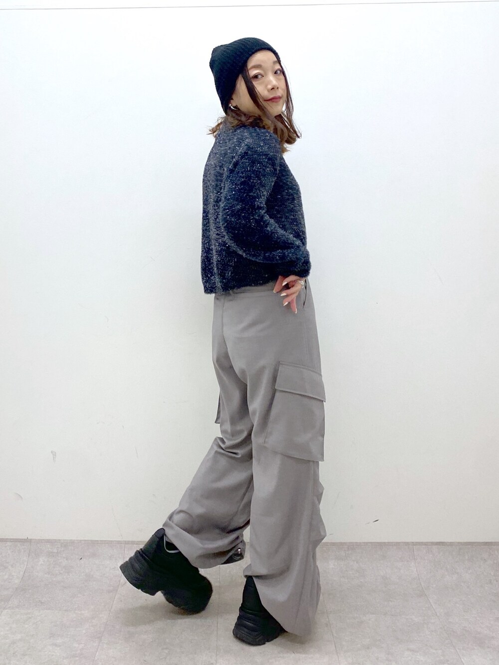 ブラック系のニット/セーター、ベージュ系のその他パンツ、ブラック系のスニーカーを着用したレディースの冬コーディネートの6枚目の写真