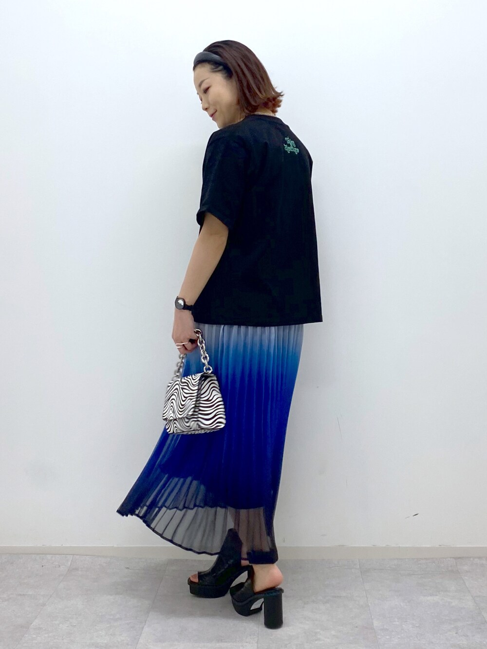 その他のショルダーバッグ、ブラック系のサンダル、ブルー系のスカートを着用したレディースの春コーディネートの3枚目の写真