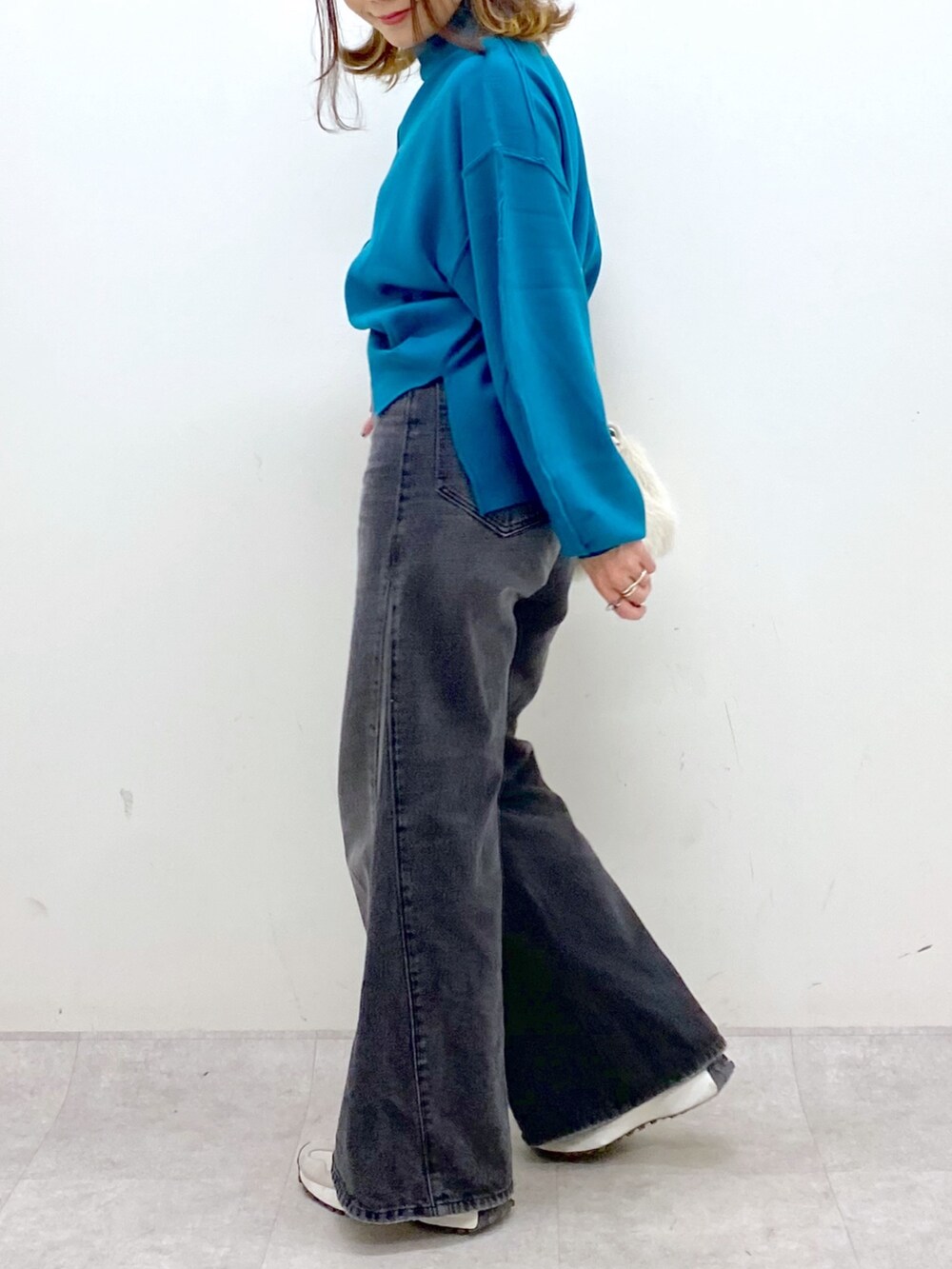 ブラック系のデニムパンツ、ホワイト系のショルダーバッグ、ブルー系のニット/セーターを着用したレディースの秋コーディネートの8枚目の写真