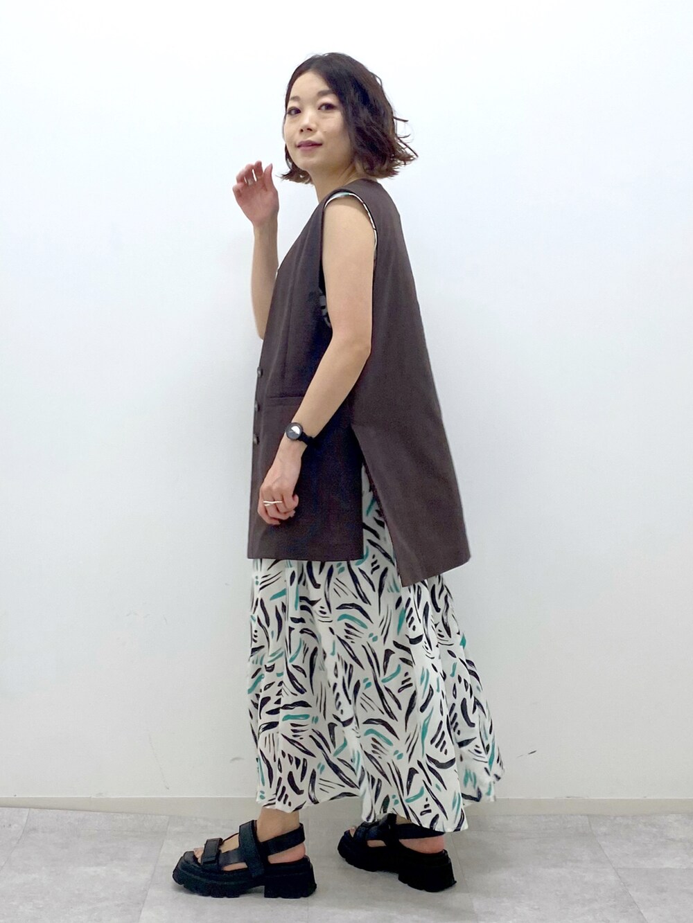 ホワイト系のワンピース、ブラウン系のその他アウター、ブラック系のサンダルを着用したレディースの夏コーディネートの3枚目の写真