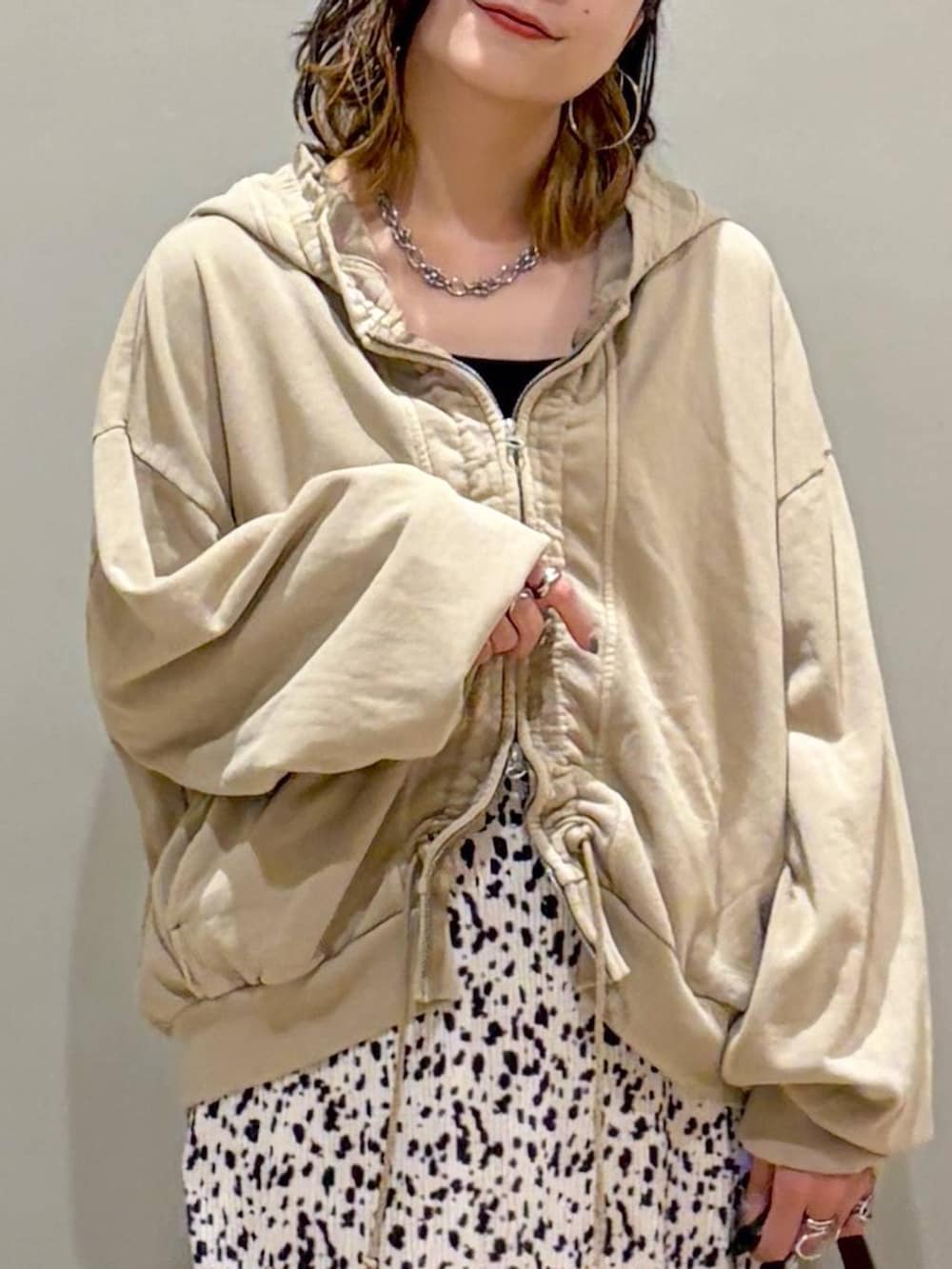ベージュ系のパーカー、ブラウン系のローファー、ホワイト系のスカートを着用したレディースの秋コーディネートの2枚目の写真