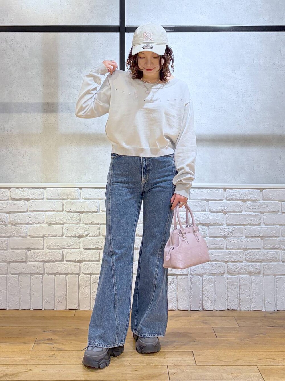 グレー系のスニーカー、ブルー系のデニムパンツ、ピンク系のハンドバッグを着用したレディースの冬コーディネートの8枚目の写真