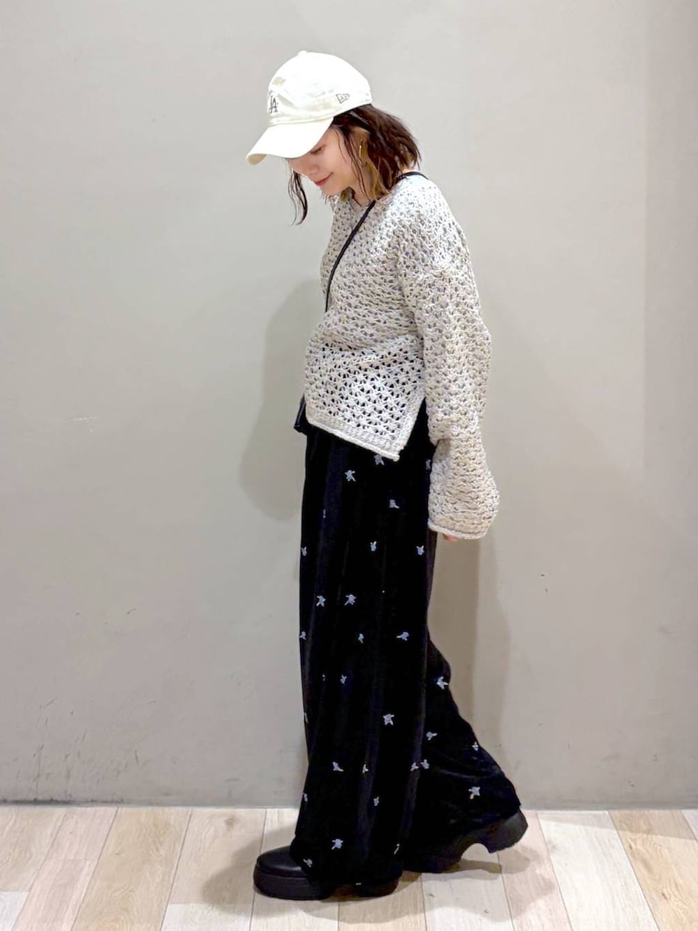 ブラック系のその他パンツ、ブラック系のブーツ、ホワイト系のニット/セーターを着用したレディースの秋コーディネートの5枚目の写真