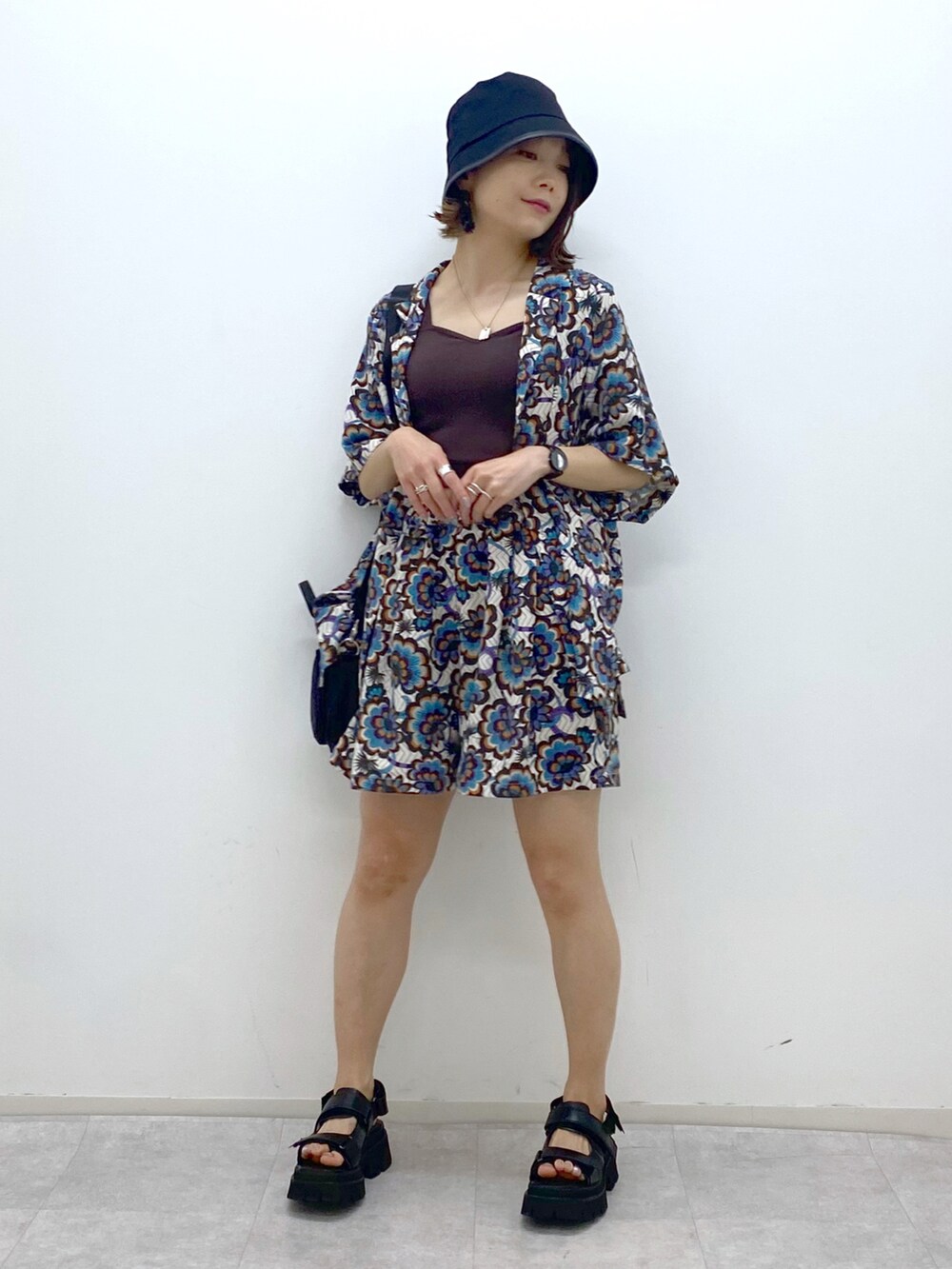 ブラウン系のタンクトップ、ホワイト系のシャツ/ブラウス、ブラック系のショルダーバッグを着用したレディースの春コーディネートの5枚目の写真