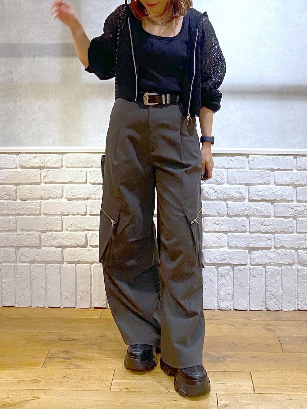 ブラック系のスニーカー、グレー系のカーゴパンツ、ブラック系のタンクトップを着用したレディースの夏コーディネートの3枚目の写真
