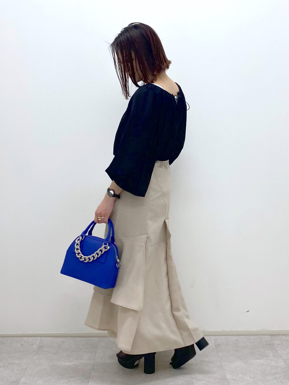 ブラック系のシャツ/ブラウス、ブルー系のショルダーバッグ、ベージュ系のスカートを着用したレディースの春コーディネートの3枚目の写真