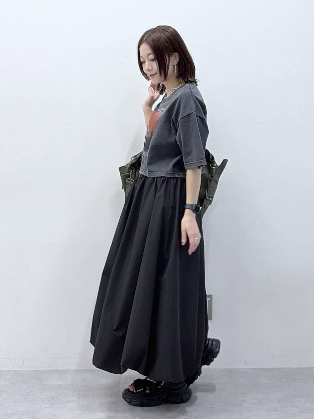 グリーン系のボストンバッグ、ブラック系のサンダル、ブラック系のスカートを着用したレディースの春コーディネートの4枚目の写真