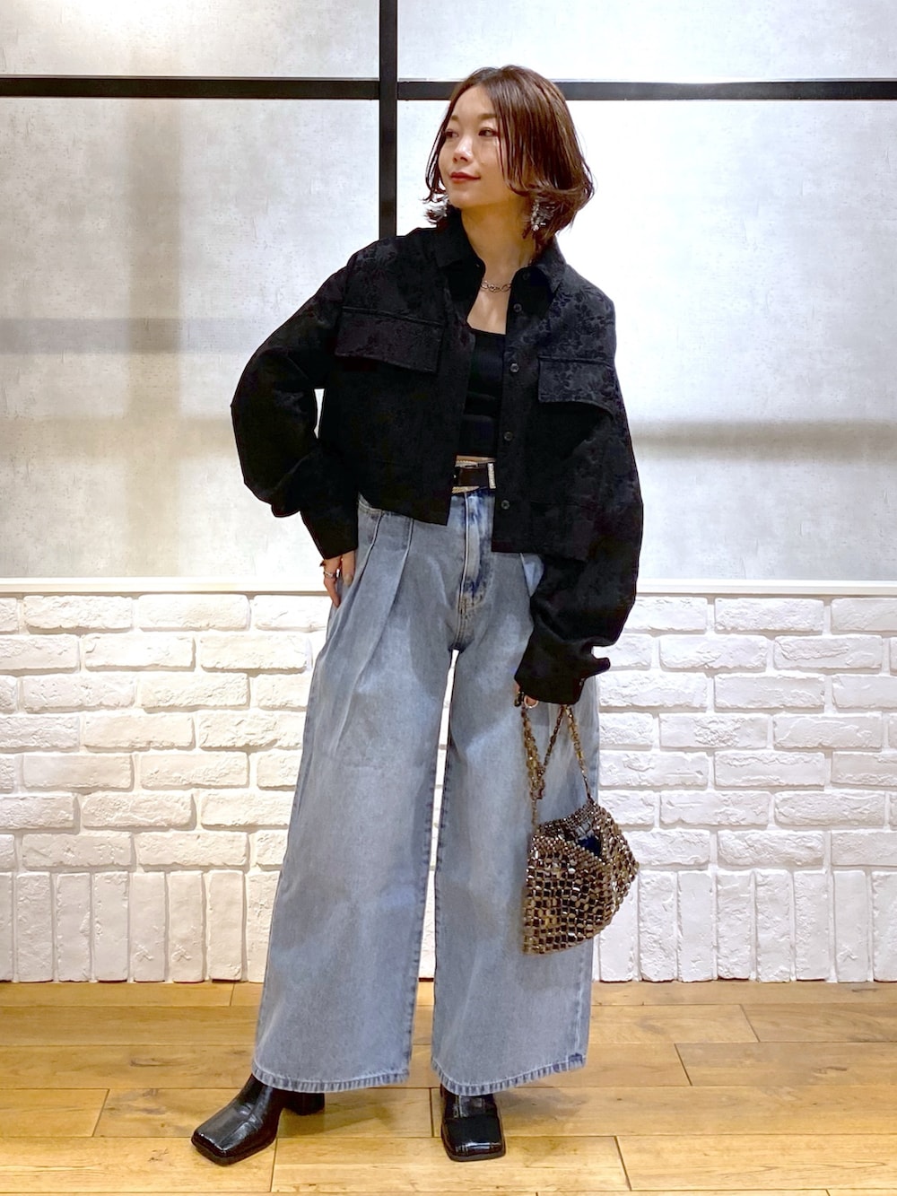 ブラック系のシャツ/ブラウス、ブルー系のデニムパンツ、ブルー系のショルダーバッグを着用したレディースの冬コーディネートの4枚目の写真