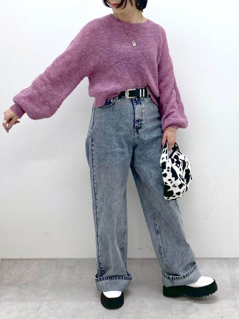 ブラック系のバッグ、ブルー系のデニムパンツ、ホワイト系のシューズを着用したレディースの冬コーディネートの4枚目の写真