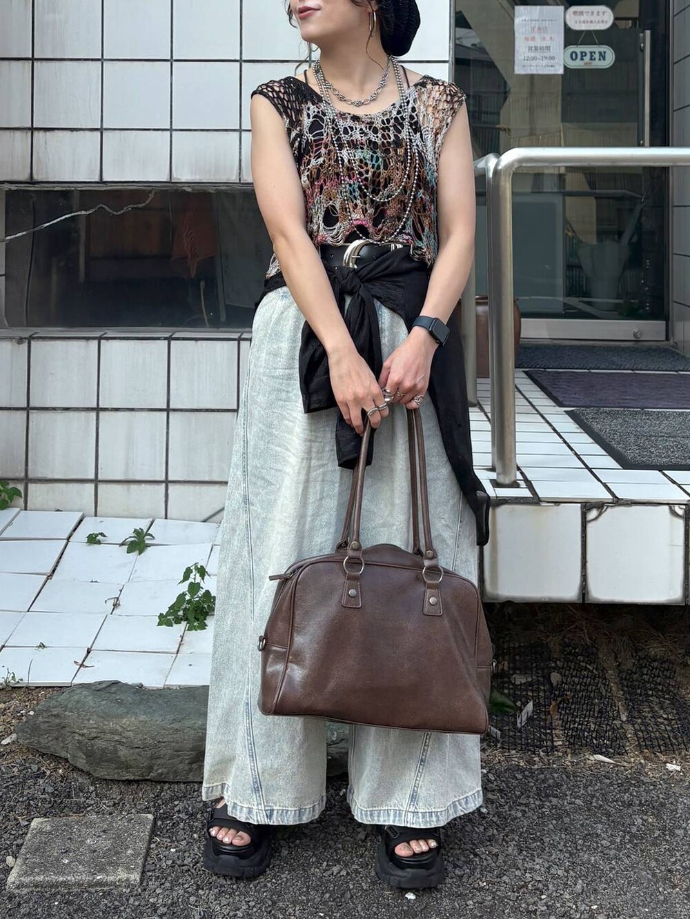 ブルー系のデニムパンツ、その他のベスト、ブラウン系のボストンバッグを着用したレディースの夏コーディネートの4枚目の写真