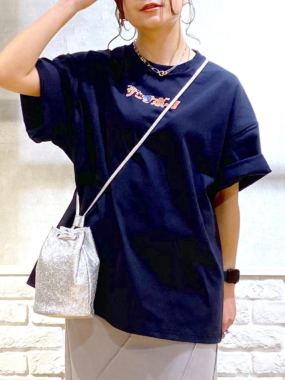 ブルー系のTシャツ/カットソー、グレー系のスカート、グレー系のスニーカーを着用したレディースの春コーディネートの2枚目の写真