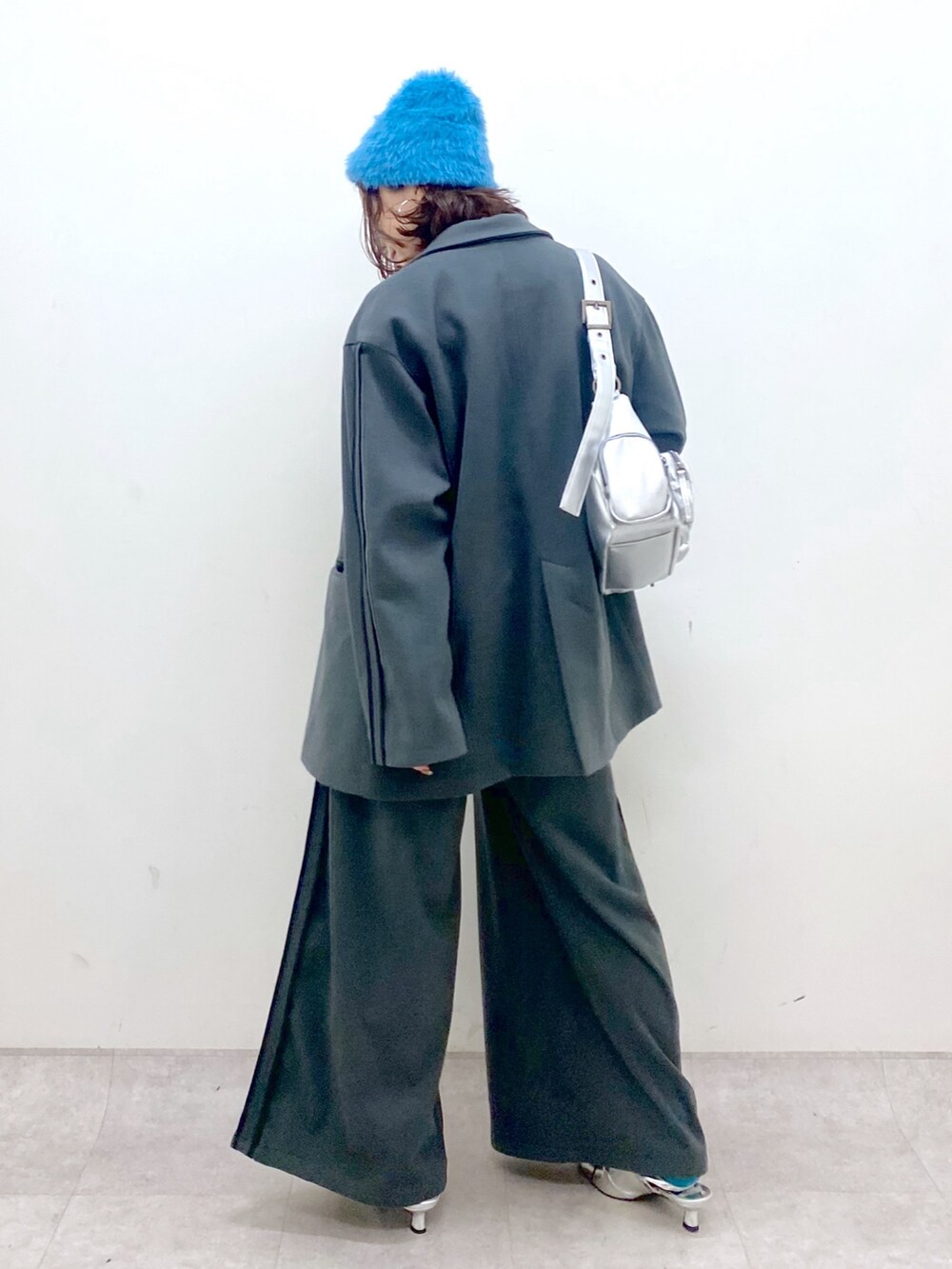 グレー系のスラックス、シルバー系のパンプス、シルバー系のショルダーバッグを着用したレディースの秋コーディネートの7枚目の写真