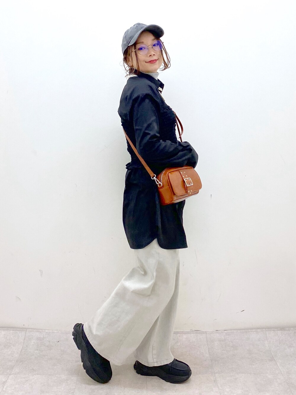 ブラック系のシャツ/ブラウス、ベージュ系のショルダーバッグ、グレー系のデニムパンツを着用したレディースの冬コーディネートの5枚目の写真