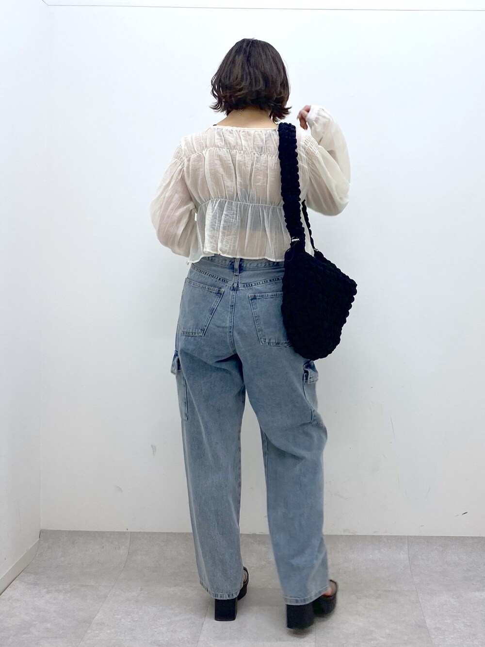 ホワイト系のシャツ/ブラウス、ブルー系のデニムパンツ、ブラック系のバッグを着用したレディースの春コーディネートの3枚目の写真