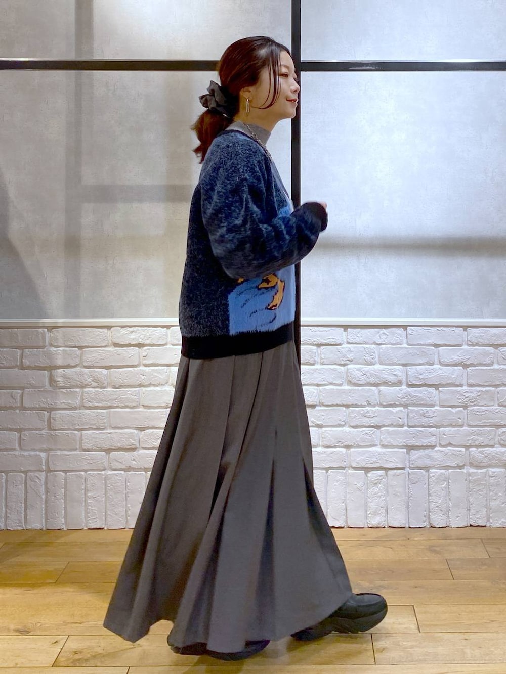 ブラック系のローファー、グレー系のスカート、ブラウン系のショルダーバッグを着用したレディースの冬コーディネートの8枚目の写真