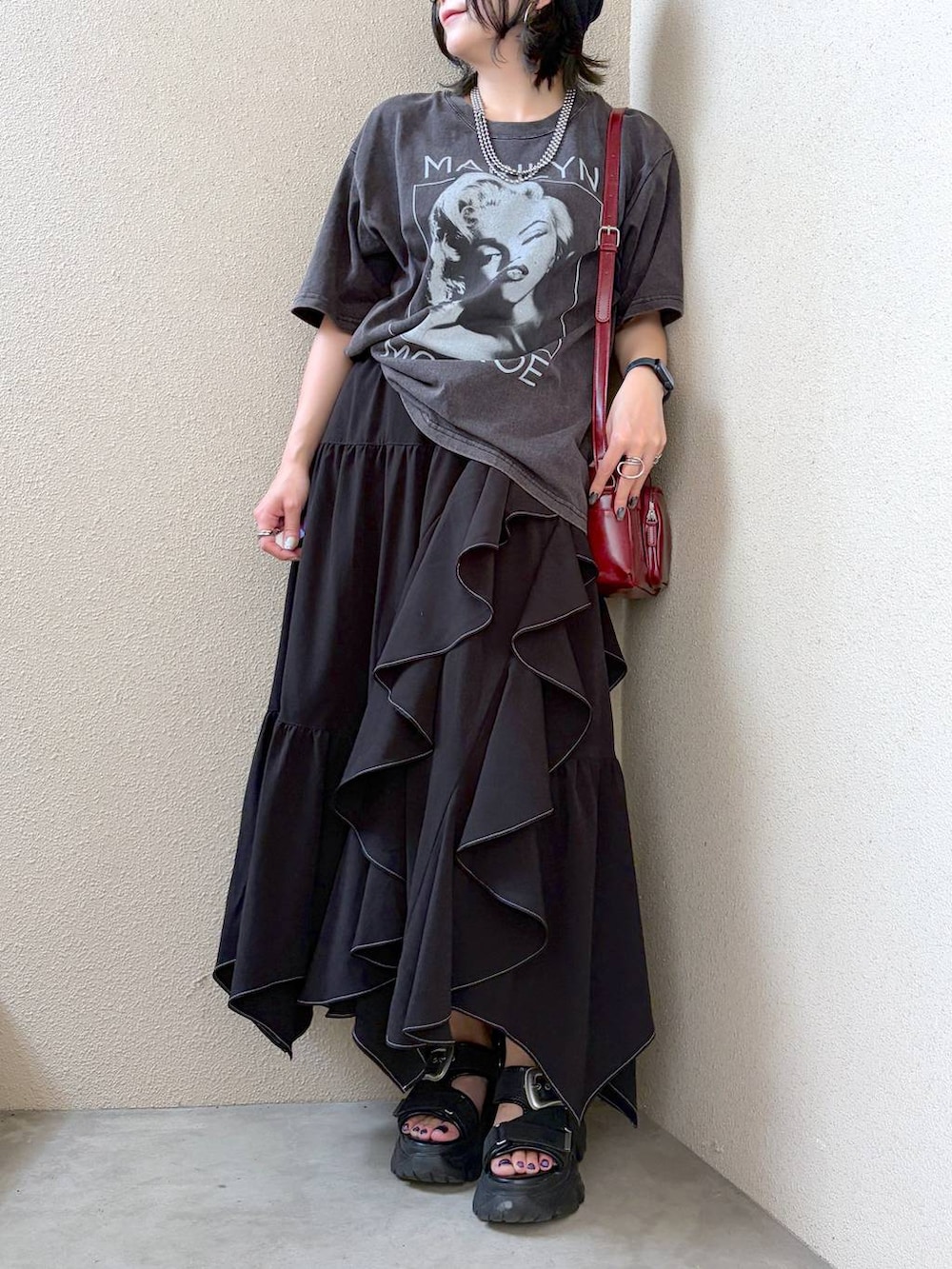 グレー系のTシャツ/カットソー、ブラック系のスカート、レッド系のショルダーバッグを着用したレディースの夏コーディネートの3枚目の写真