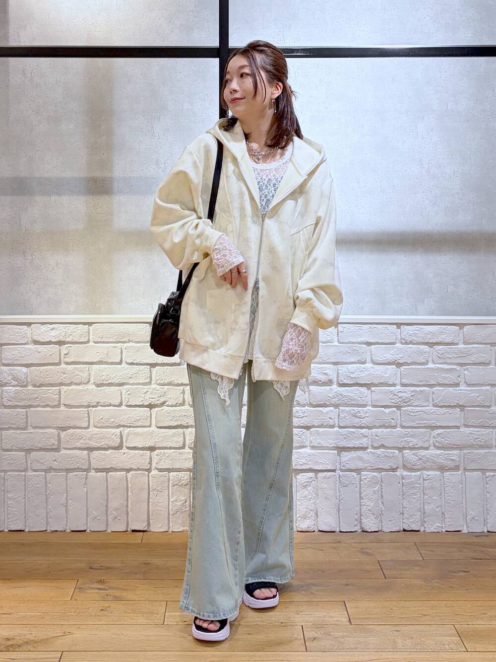 ブルー系のデニムパンツ、ホワイト系のパーカー、ホワイト系のチュニックを着用したレディースの春コーディネートの9枚目の写真