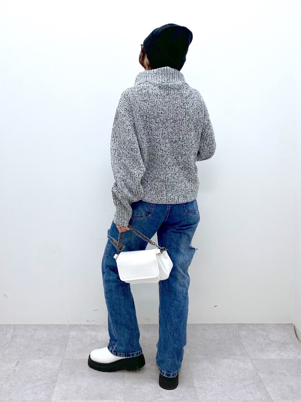 ホワイト系のバッグ、ブルー系のデニムパンツ、ホワイト系のシューズを着用したレディースの秋コーディネートの3枚目の写真