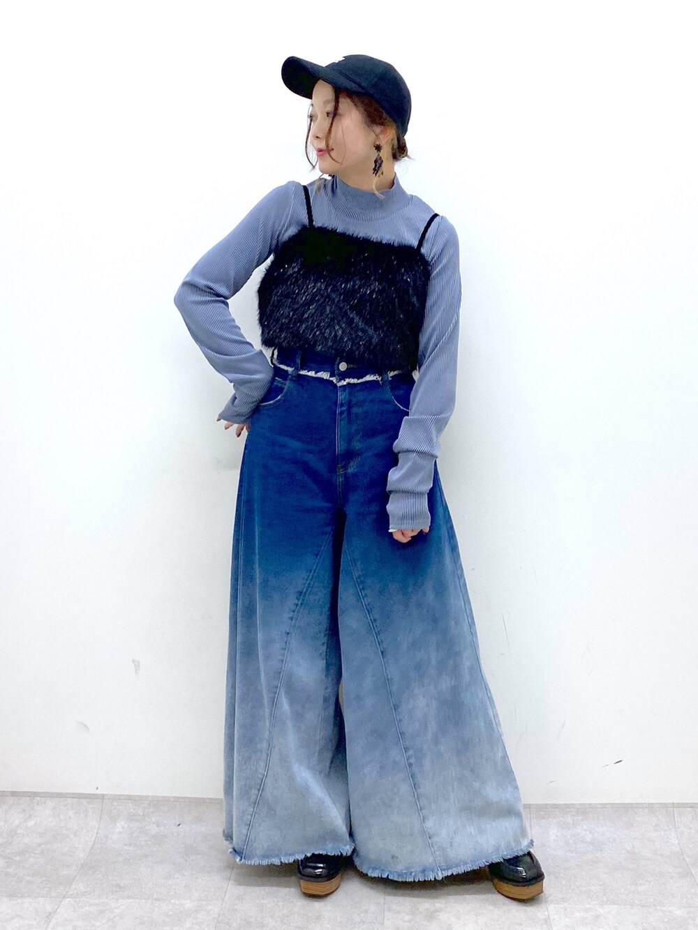 ブルー系のデニムパンツ、ブラック系のベスト、ブルー系のTシャツ/カットソーを着用したレディースの秋コーディネートの2枚目の写真