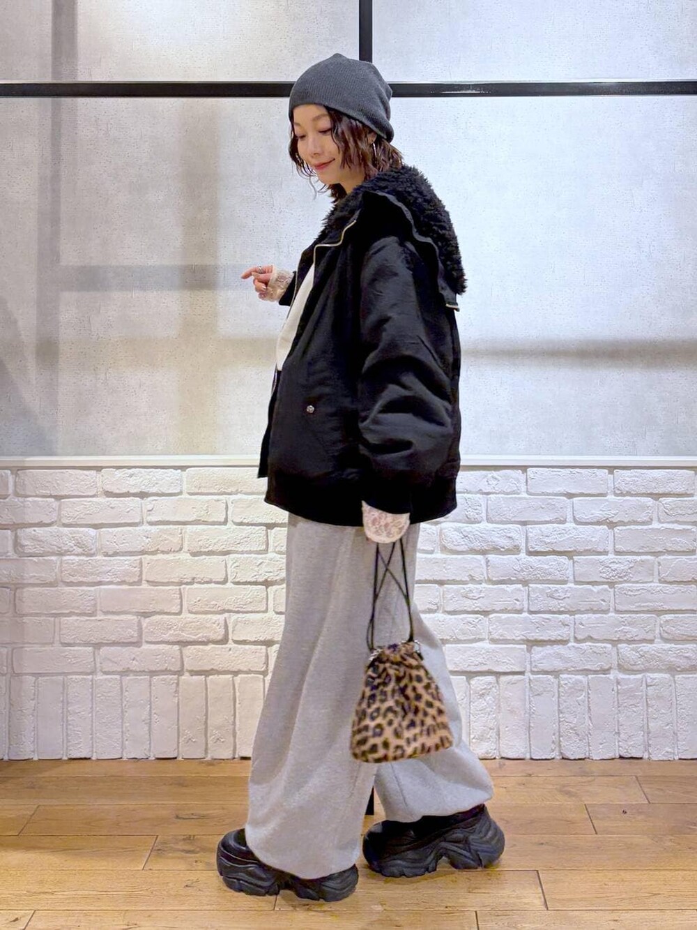 ブラック系のブーツ、グレー系のスウェットパンツ、ブラック系のブルゾンを着用したレディースの冬コーディネートの7枚目の写真