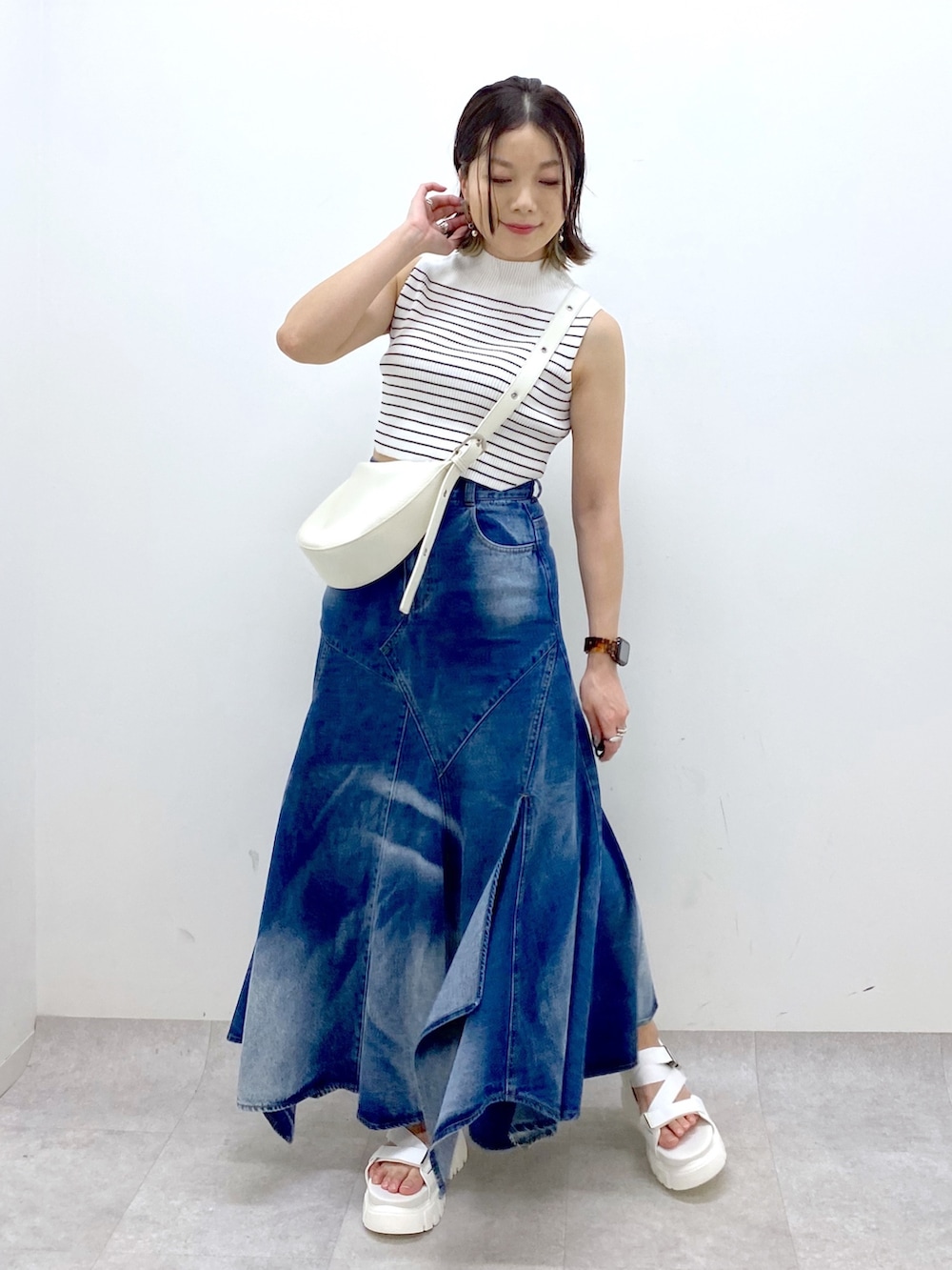 ホワイト系のショルダーバッグ、ブルー系のスカート、ホワイト系のTシャツ/カットソーを着用したレディースの夏コーディネートの9枚目の写真