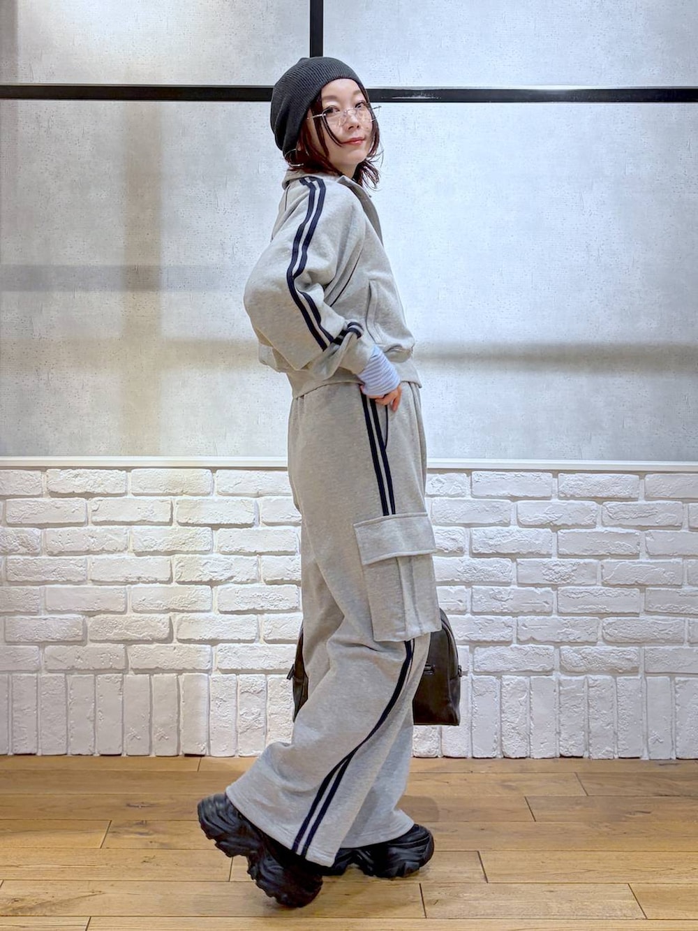 ブラック系のブーツ、ブラック系のボストンバッグ、グレー系のジャージを着用したレディースの冬コーディネートの6枚目の写真