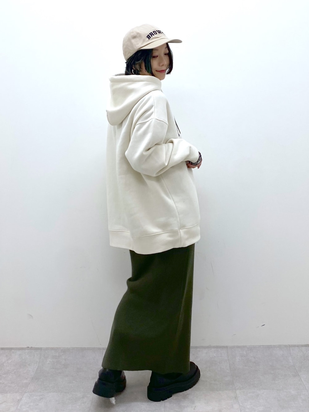 ホワイト系のパーカー、ブラック系のトップス、ブラック系のシューズを着用したレディースの秋コーディネートの2枚目の写真