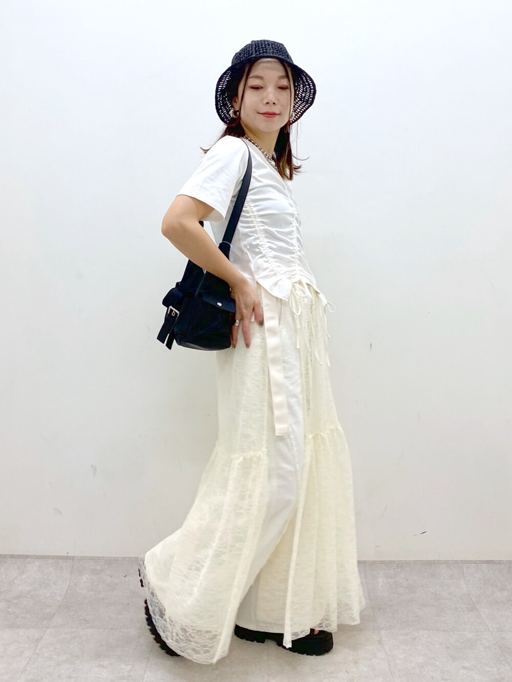 ホワイト系のTシャツ/カットソー、ブラック系のサンダル、ホワイト系のデニムパンツを着用したレディースの春コーディネートの7枚目の写真