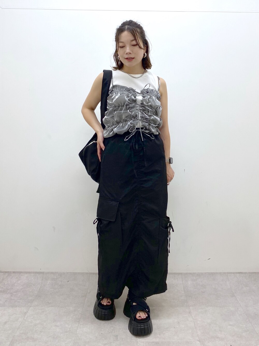 ブラック系のスニーカー、ブラック系のスカート、ブラック系のショルダーバッグを着用したレディースの夏コーディネートの8枚目の写真