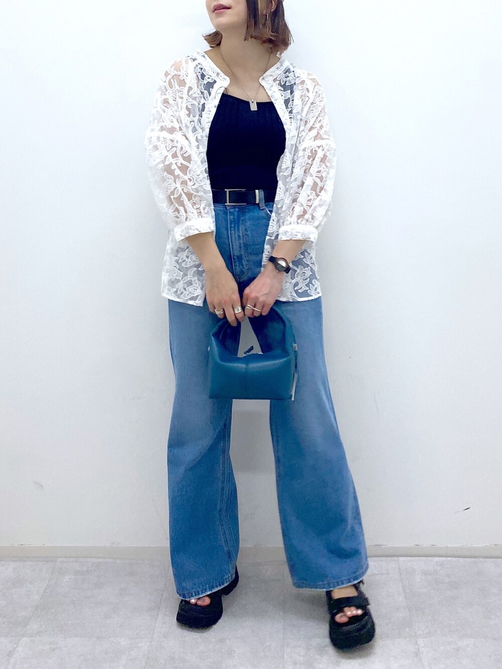 ブルー系のパンツ、ブラック系のサンダル、ブルー系のショルダーバッグを着用したレディースの夏コーディネートの5枚目の写真