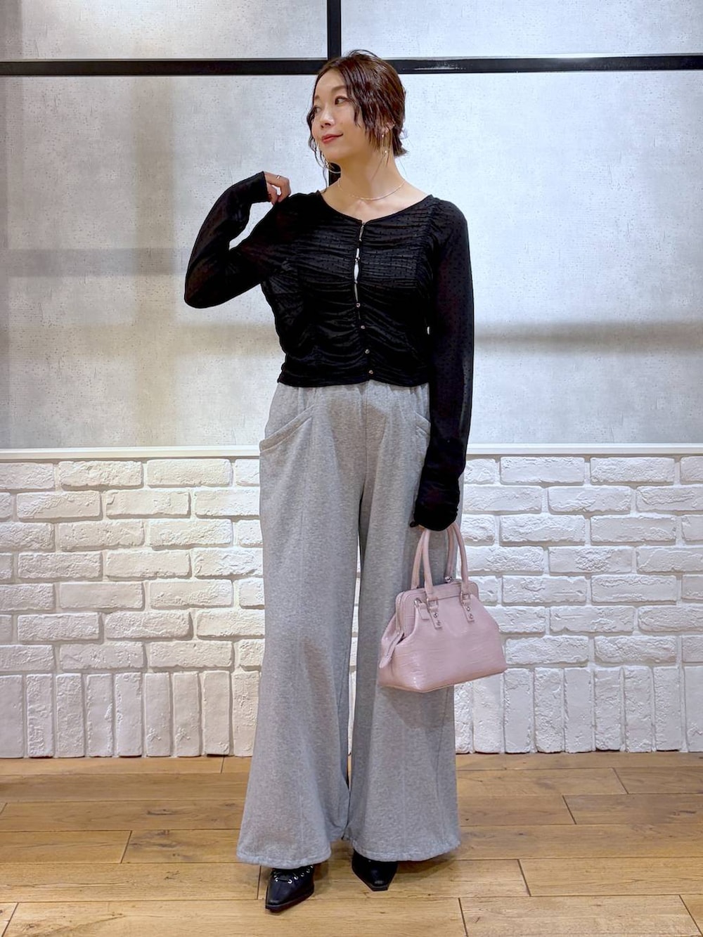 ホワイト系のキャミソール、ピンク系のハンドバッグ、グレー系のスウェットパンツを着用したレディースの春コーディネートの8枚目の写真