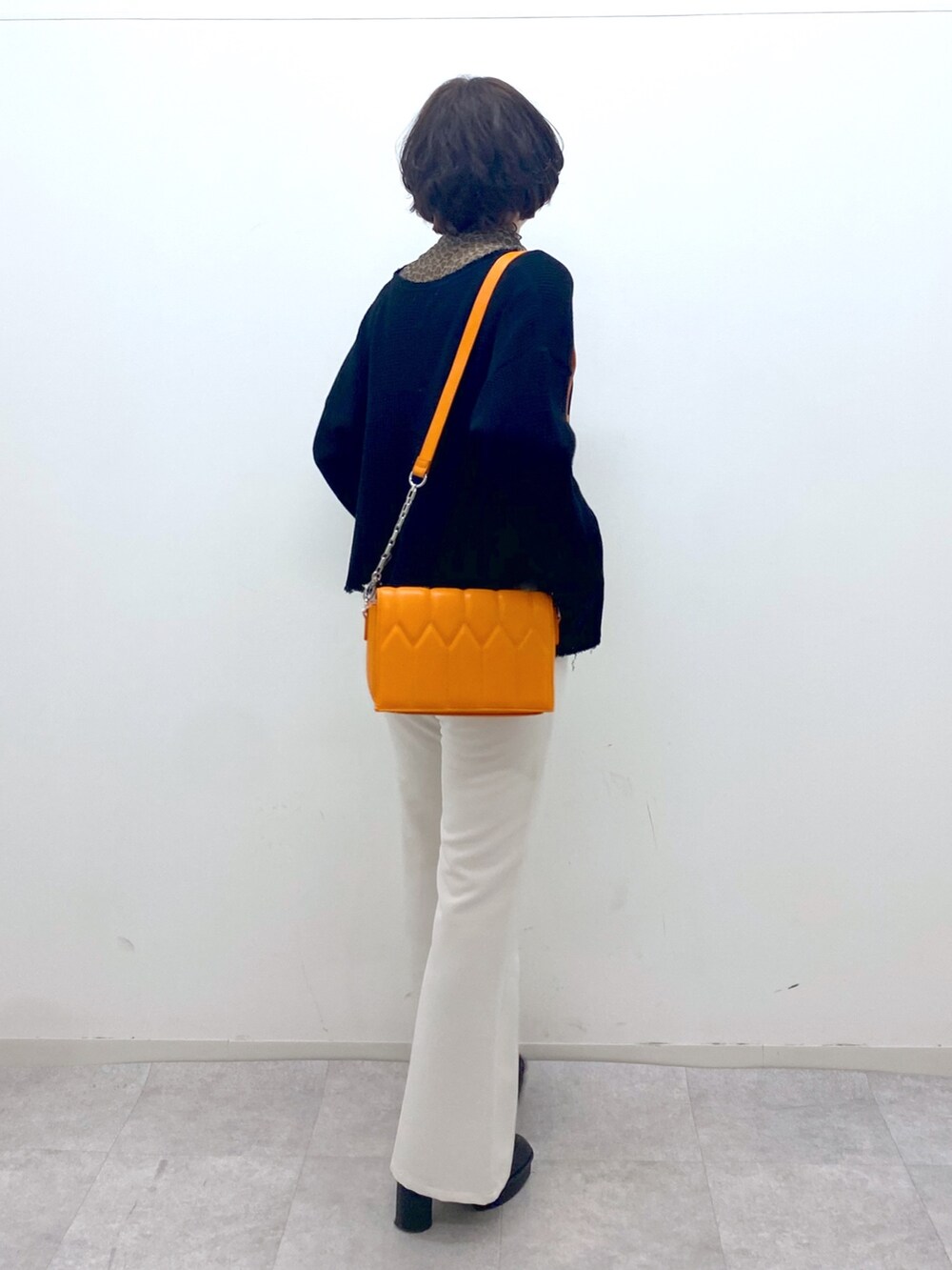 ホワイト系のパンツ、その他のその他トップス、オレンジ系のショルダーバッグを着用したレディースの秋コーディネートの2枚目の写真