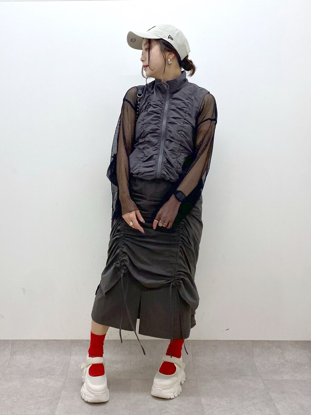 グレー系のスカート、ブラック系のショルダーバッグ、ブラック系のTシャツ/カットソーを着用したレディースの春コーディネートの9枚目の写真