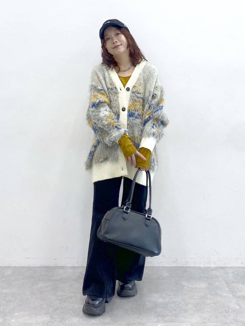 ブラック系のブーツ、ブラック系のボストンバッグ、ホワイト系のカーディガン/ボレロを着用したレディースの秋コーディネートの9枚目の写真