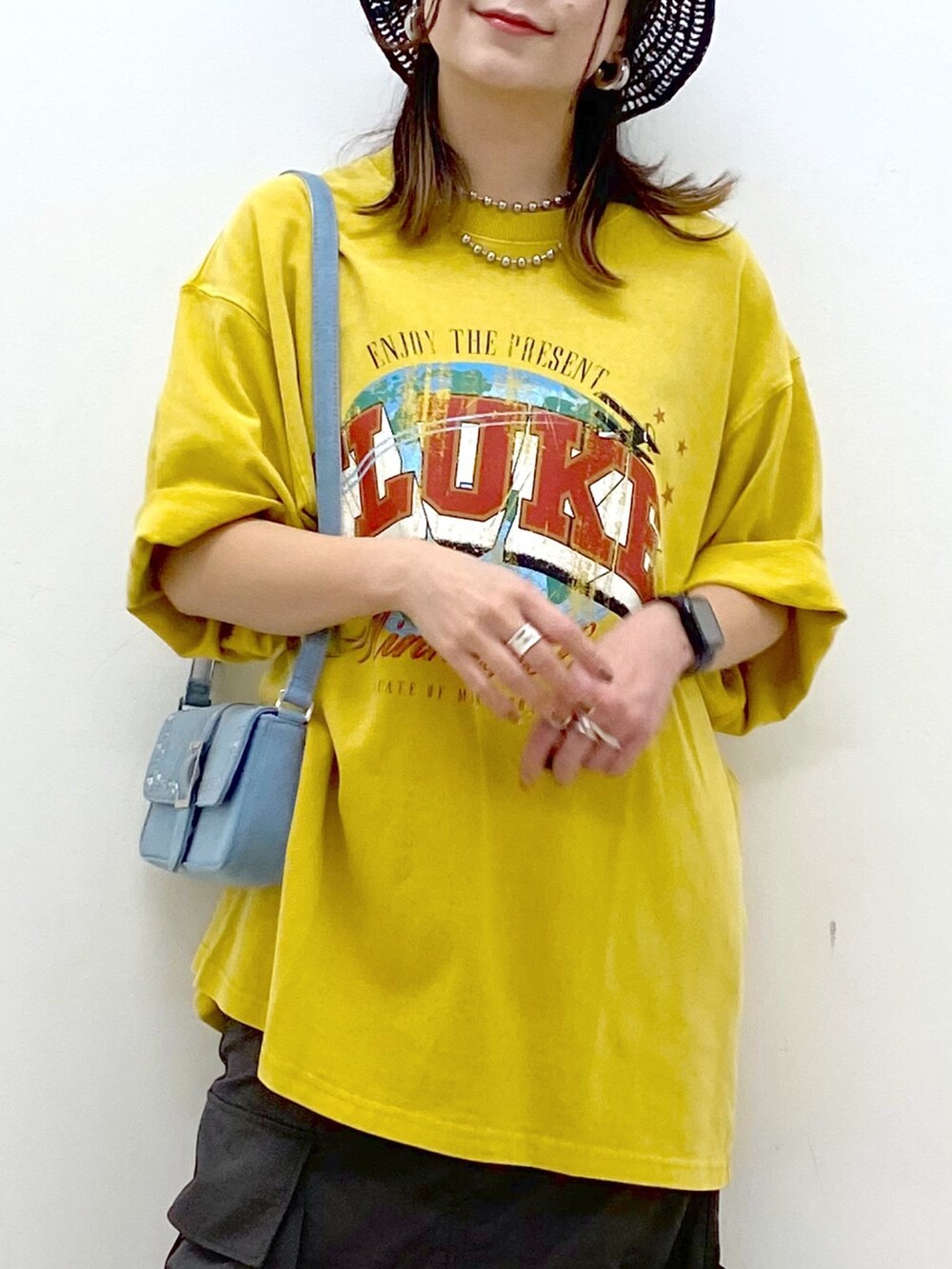 グレー系のスカート、ホワイト系のサンダル、ブルー系のハンドバッグを着用したレディースの春コーディネートの2枚目の写真